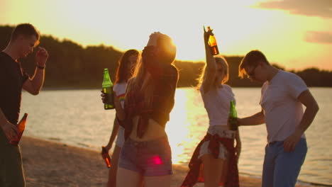 The-young-women-with-blonde-hair-is-dancing-with-slim-figure-on-the-open-air-party-with-beer.-It-is-crazy-and-enjoyable-beach-party-with-the-best-friends-in-the-good-mood.